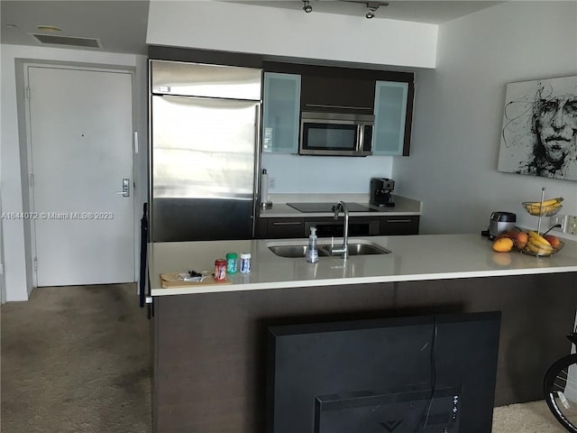 kitchen with stainless steel appliances, sink, and concrete flooring