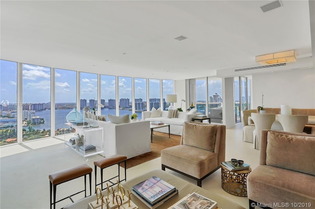 living room with a water view, floor to ceiling windows, and a healthy amount of sunlight