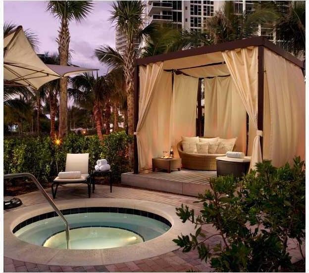 pool at dusk featuring outdoor lounge area, a patio, and an in ground hot tub