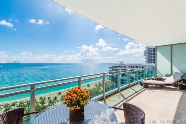 balcony featuring a water view and a beach view