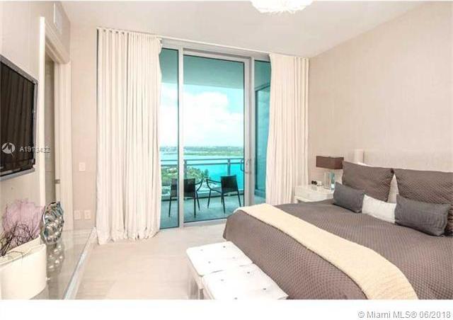 bedroom with access to exterior and a water view