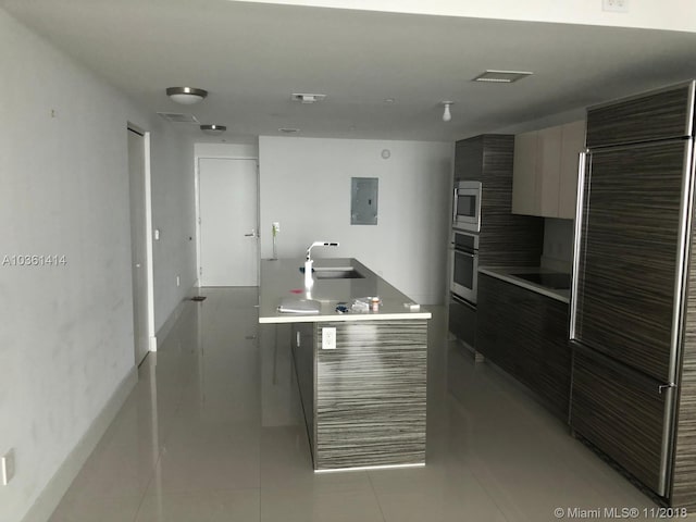 kitchen featuring electric panel, stainless steel appliances, light tile patterned flooring, and sink