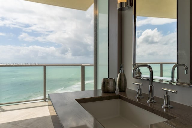 balcony featuring a water view and sink