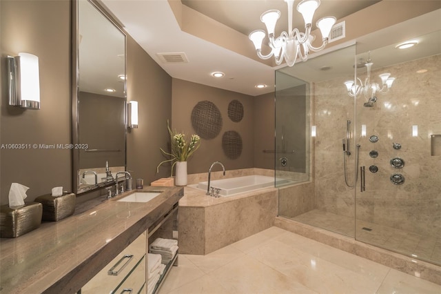 bathroom with tile patterned flooring, independent shower and bath, a notable chandelier, and vanity