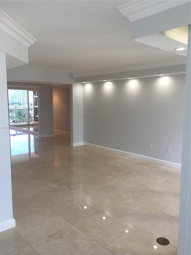 tiled spare room featuring crown molding