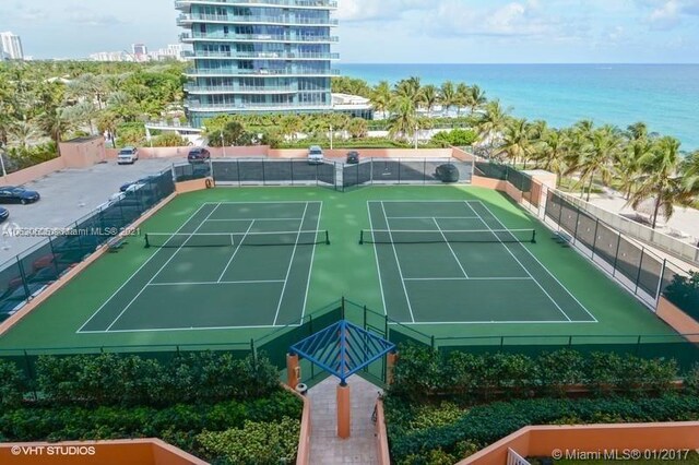 view of tennis court with a water view