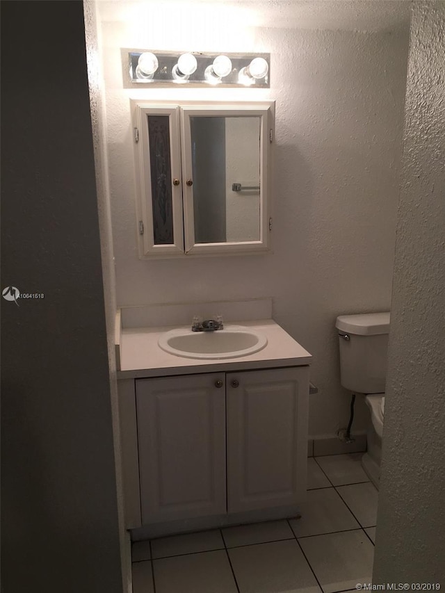 bathroom featuring tile patterned floors, vanity, and toilet