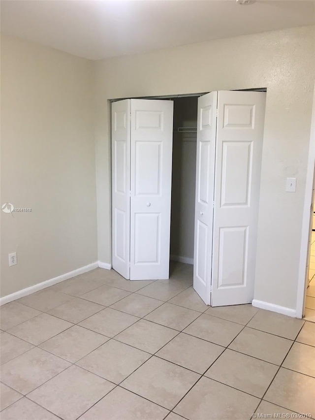 unfurnished bedroom featuring light tile patterned flooring and a closet