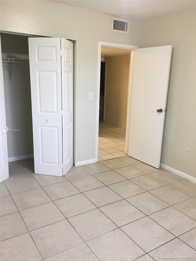 unfurnished bedroom with light tile patterned floors and a closet