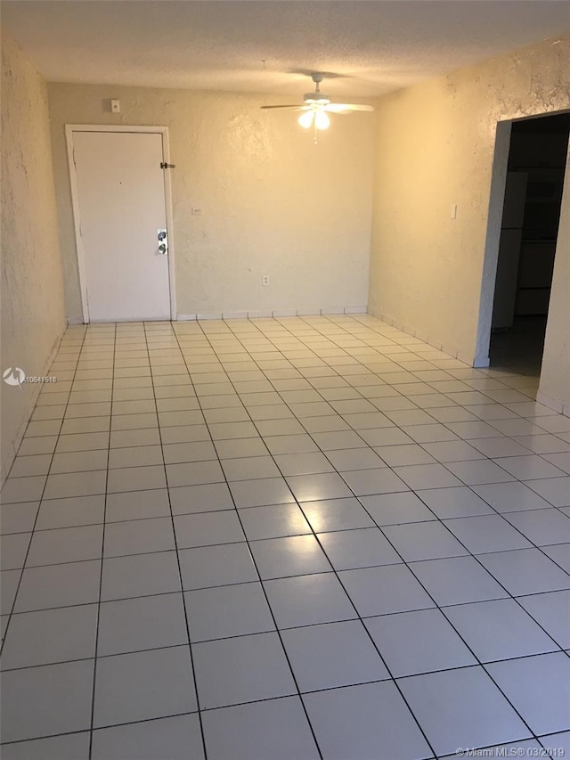 empty room featuring light tile patterned floors and ceiling fan