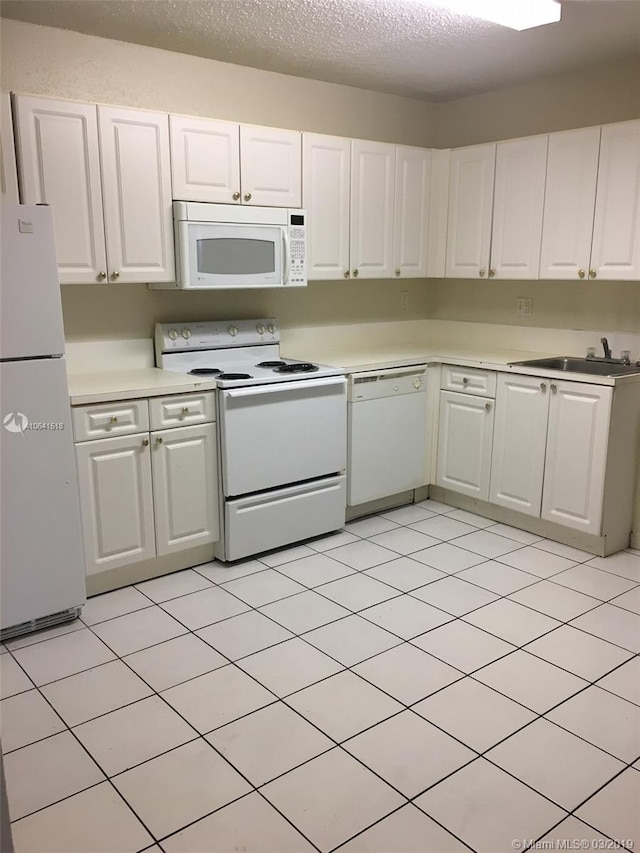 kitchen with white cabinetry and white appliances