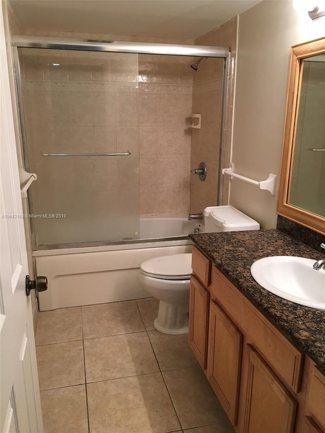 full bathroom featuring vanity, combined bath / shower with glass door, tile floors, and toilet