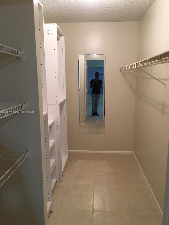 spacious closet featuring light tile flooring