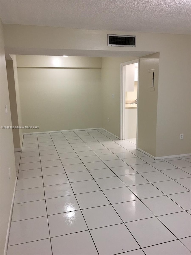 spare room with light tile floors and a textured ceiling