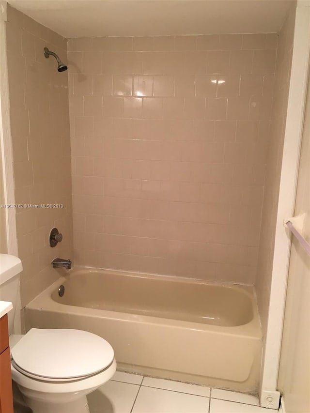 full bathroom with tiled shower / bath combo, vanity, tile flooring, and toilet