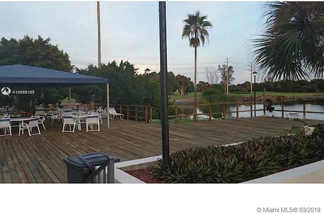 wooden terrace featuring a gazebo and a water view