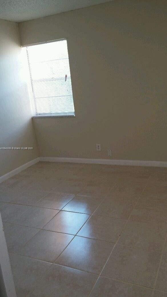 unfurnished room with tile patterned flooring and a textured ceiling