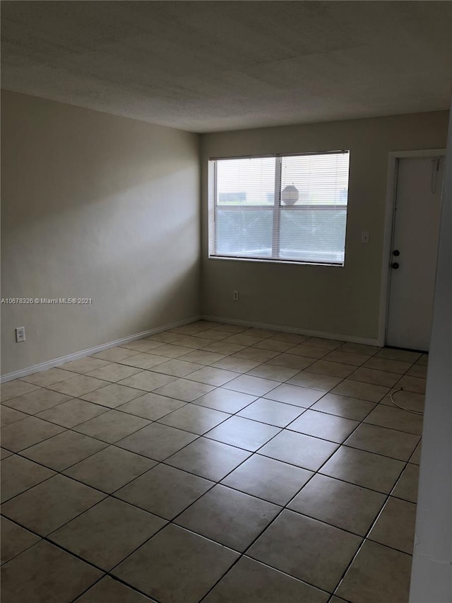 unfurnished room featuring light tile patterned floors