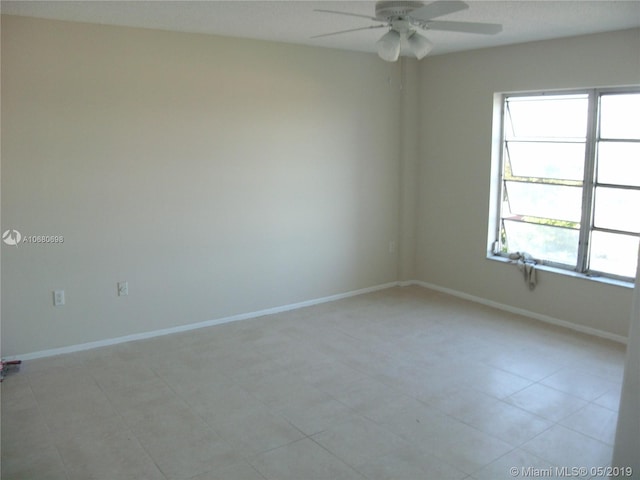 spare room featuring ceiling fan and light tile floors