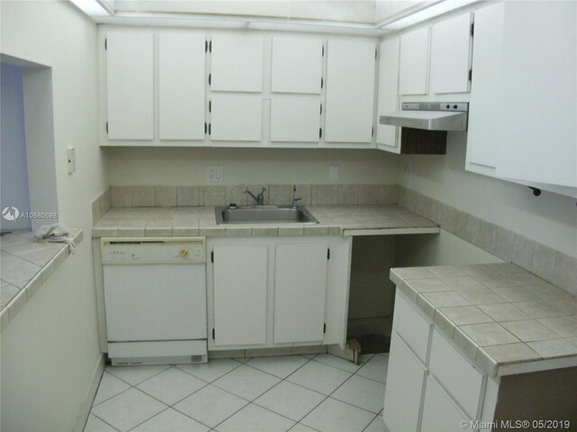 kitchen featuring white dishwasher, tile countertops, white cabinetry, and sink