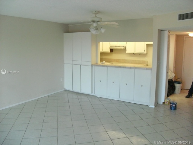 interior space featuring light tile floors and ceiling fan