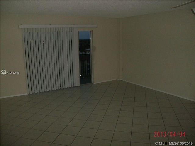 unfurnished room featuring tile flooring and a textured ceiling