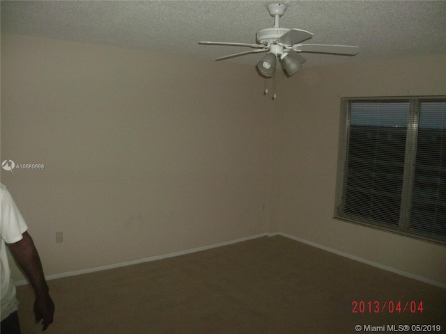 carpeted empty room featuring a textured ceiling and ceiling fan