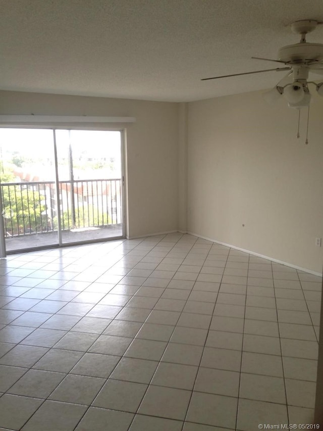 tiled empty room with ceiling fan