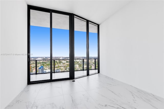 tiled spare room with floor to ceiling windows and a wealth of natural light