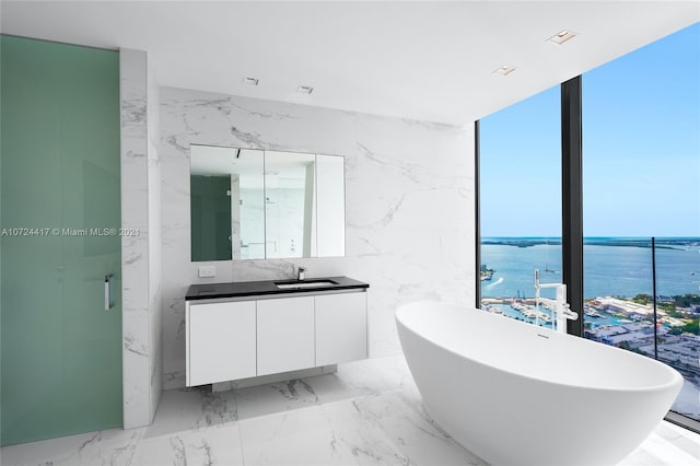 bathroom featuring tile walls, large vanity, tile floors, and a bathtub