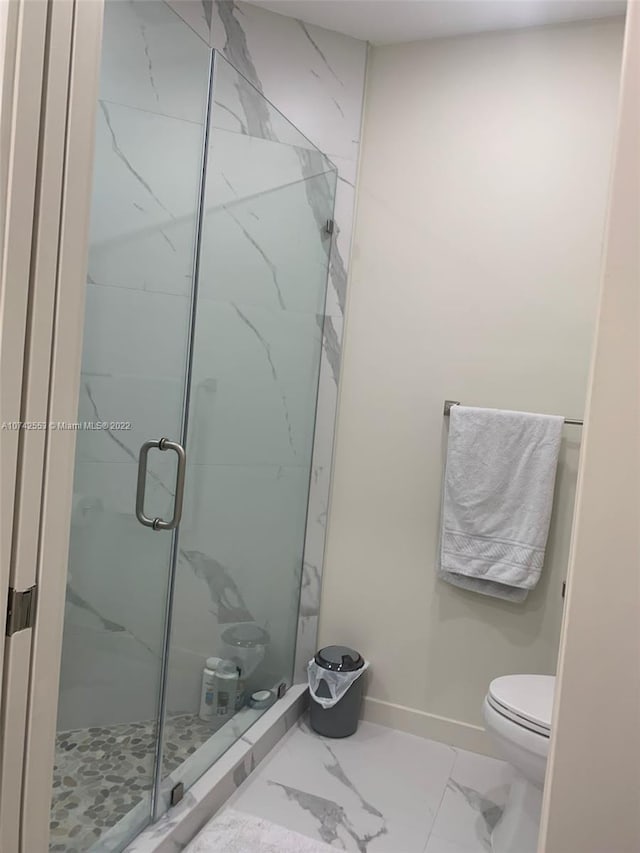 bathroom with a shower with door, tile floors, and toilet