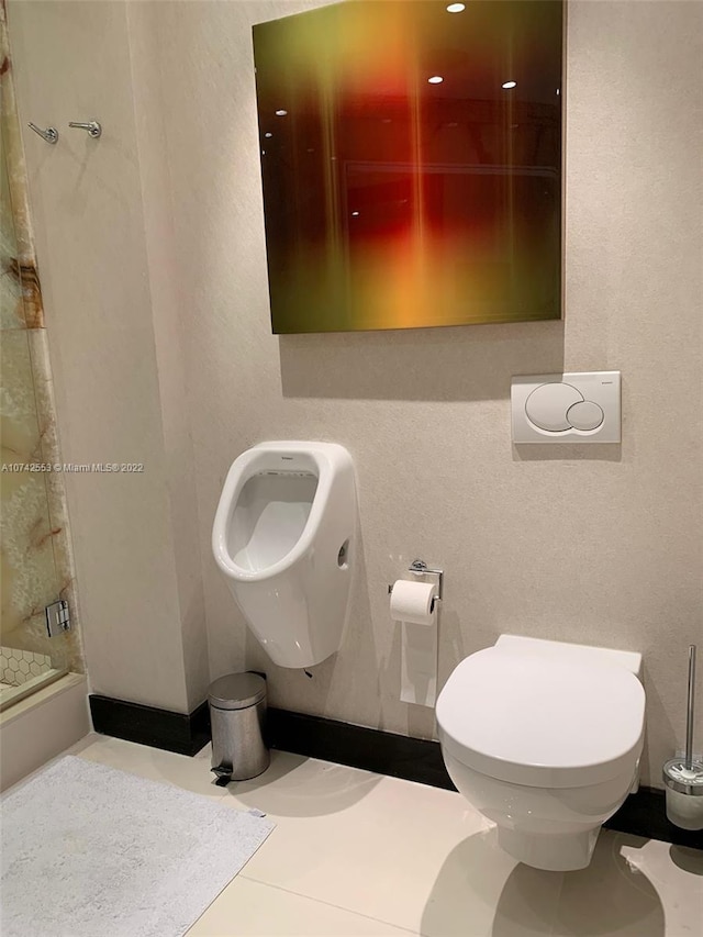 bathroom featuring a tile shower and toilet