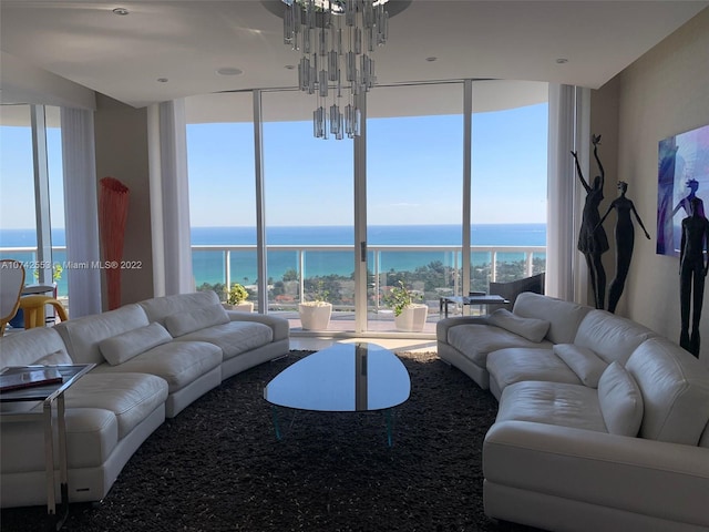 living room with a water view, a wall of windows, a chandelier, and a wealth of natural light