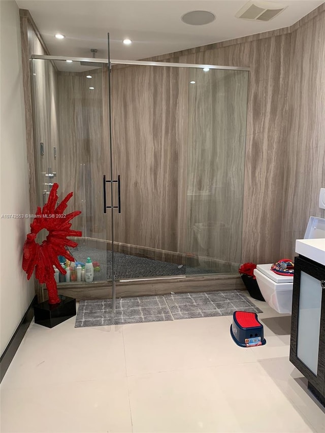 bathroom with an enclosed shower, vanity, and tile flooring