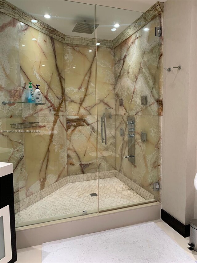 bathroom with walk in shower, tile floors, and vanity