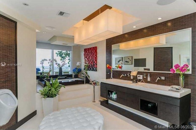 bathroom featuring vanity, tile flooring, and backsplash