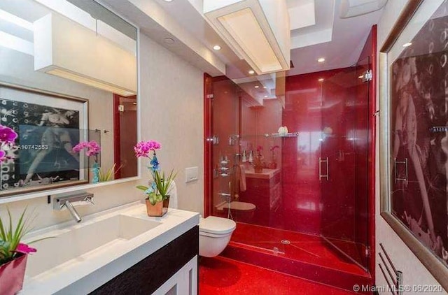 bathroom with toilet, a tile shower, vanity with extensive cabinet space, and tile flooring