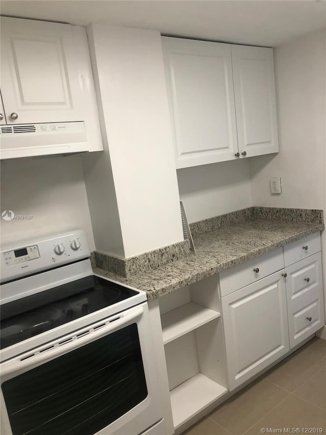 kitchen featuring white cabinets, electric range, extractor fan, and light tile patterned flooring