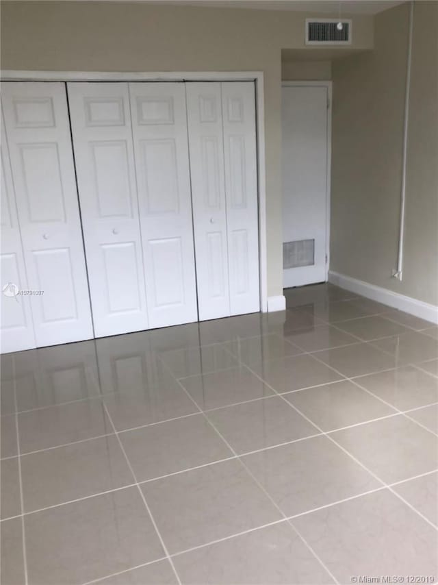 unfurnished bedroom featuring tile patterned floors and a closet