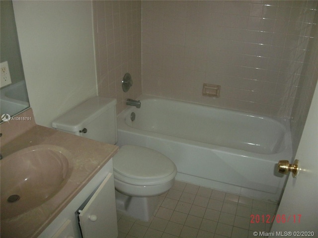 full bathroom featuring tile patterned flooring, vanity, tiled shower / bath combo, and toilet