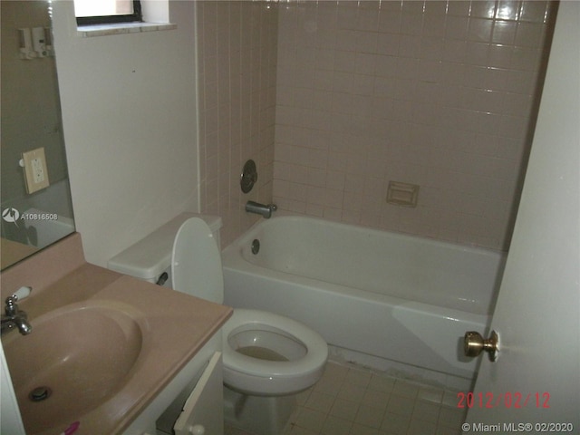 full bathroom with tile patterned flooring, vanity, tiled shower / bath combo, and toilet