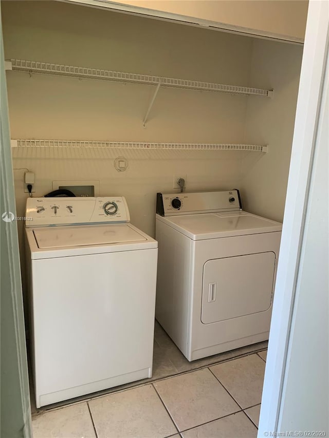 washroom with washer and clothes dryer and light tile patterned flooring