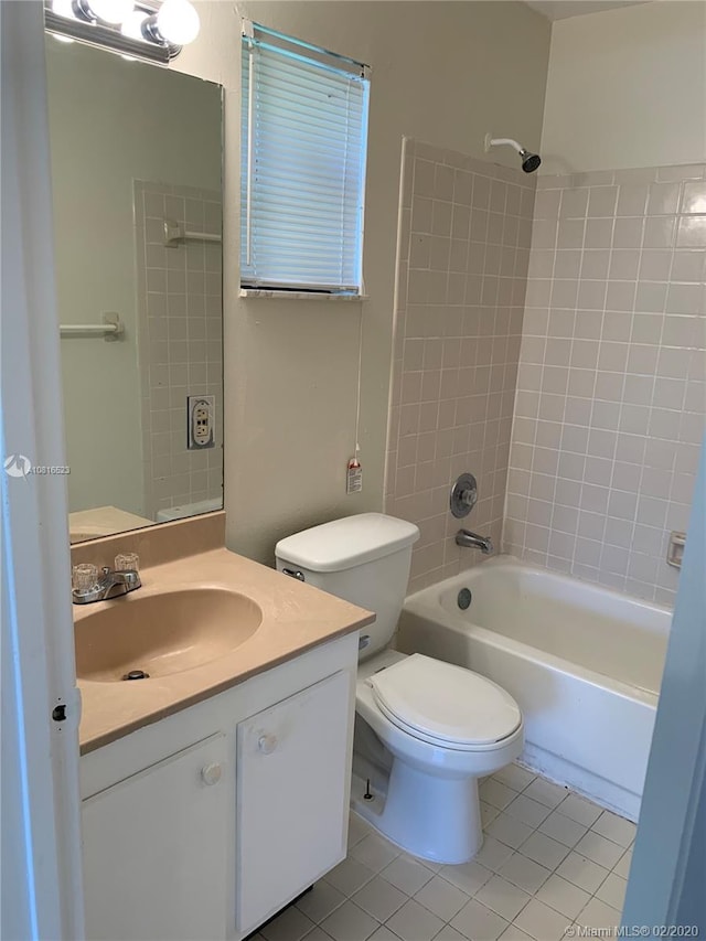 full bathroom featuring tile patterned flooring, vanity, tiled shower / bath combo, and toilet