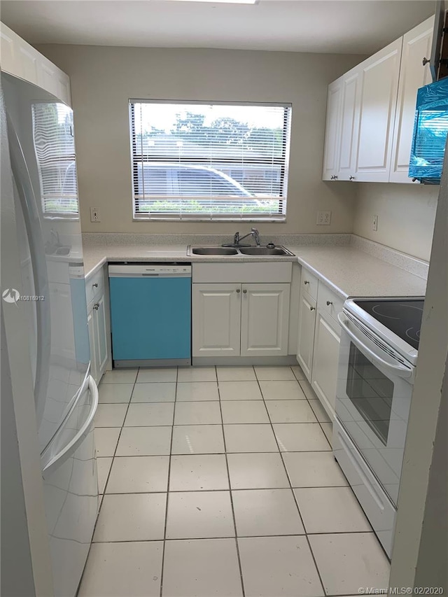 kitchen with light tile patterned floors, white appliances, white cabinetry, and sink