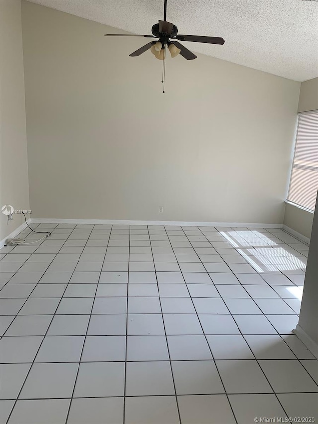 tiled spare room with a textured ceiling, ceiling fan, and lofted ceiling