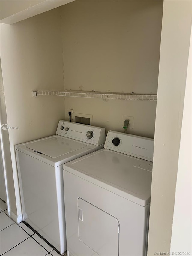 laundry area featuring independent washer and dryer and light tile patterned floors