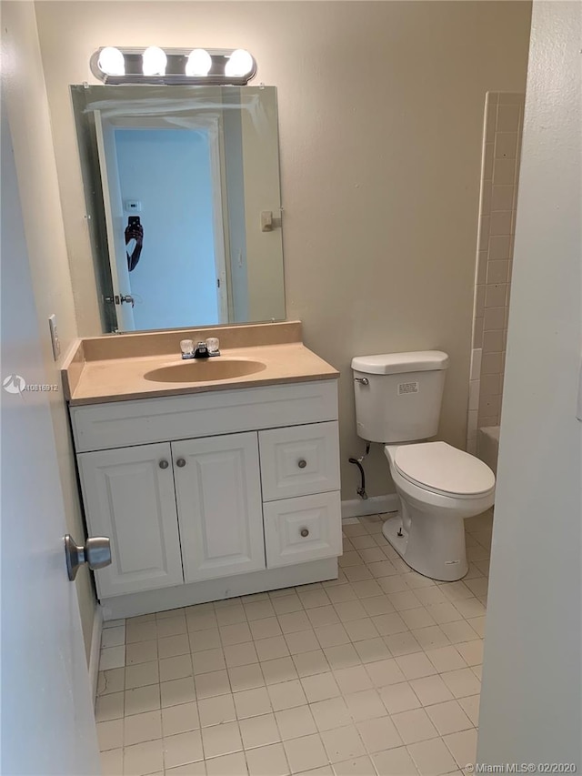 bathroom featuring tile patterned flooring, vanity, and toilet