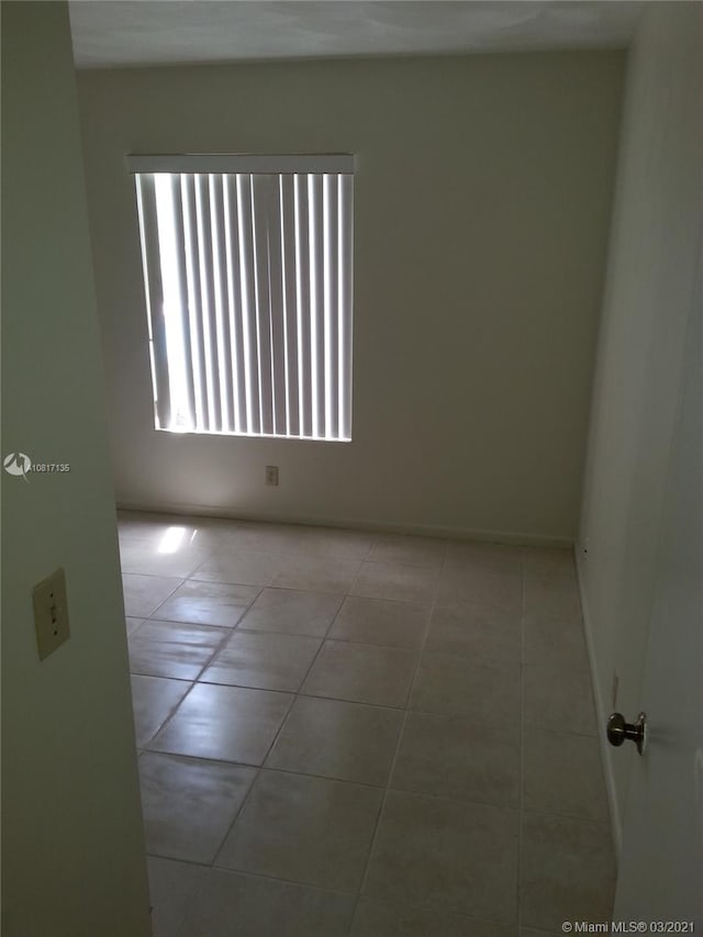 unfurnished room with light tile patterned flooring