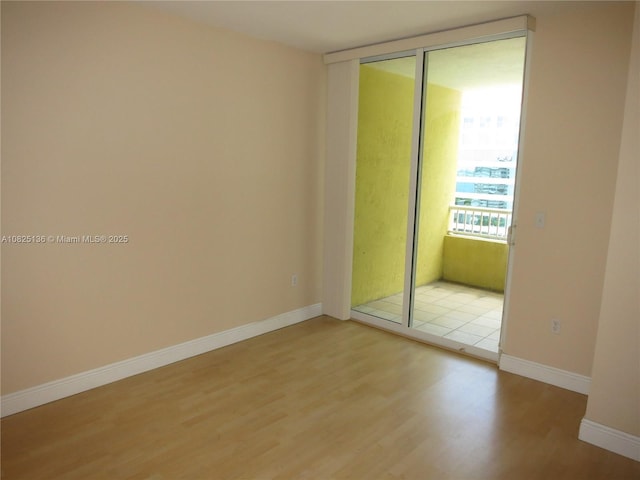 empty room with light wood-style flooring and baseboards