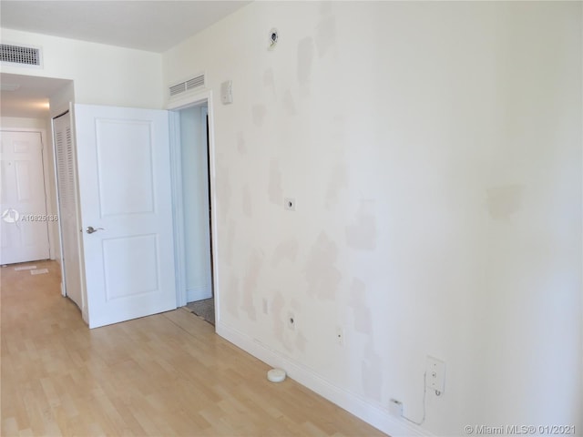 spare room featuring baseboards, visible vents, and light wood finished floors